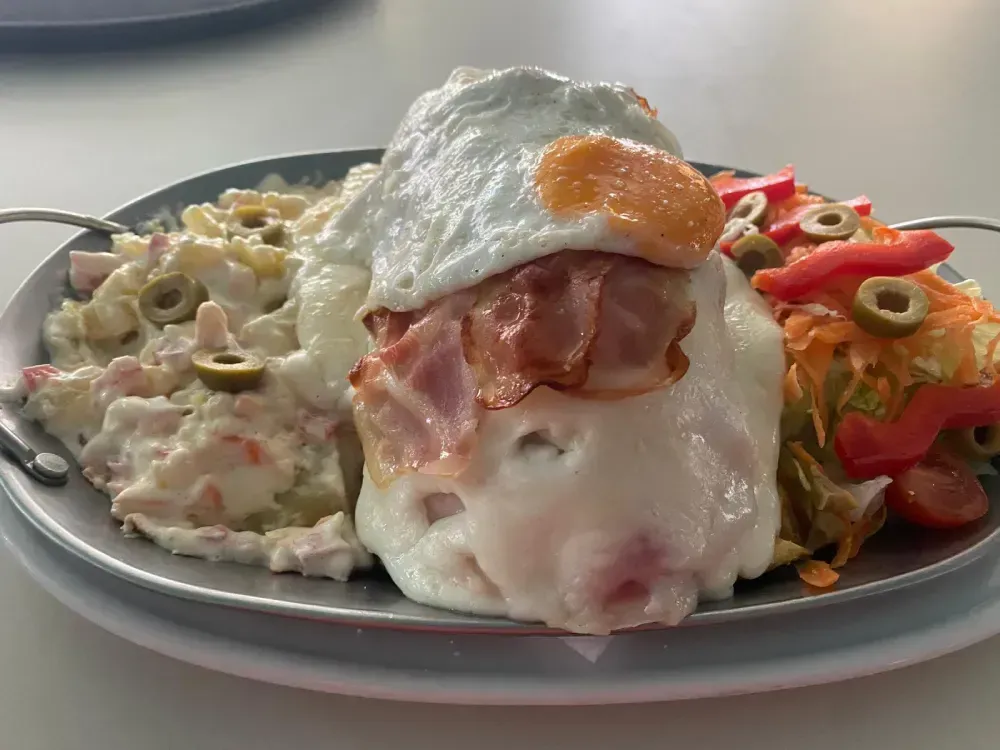 Chuletas de cordero a la parrilla en un recipiente de terracota sobre una tabla de madera.