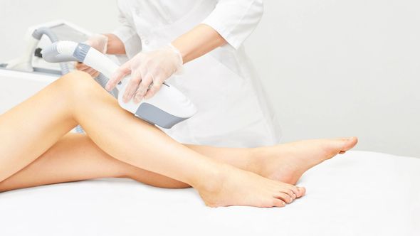 Eine Frau lässt sich an den Beinen eine Laser-Haarentfernung durchführen.