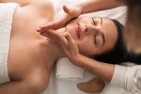 Eine Frau bekommt in einem Spa eine Gesichtsmassage.