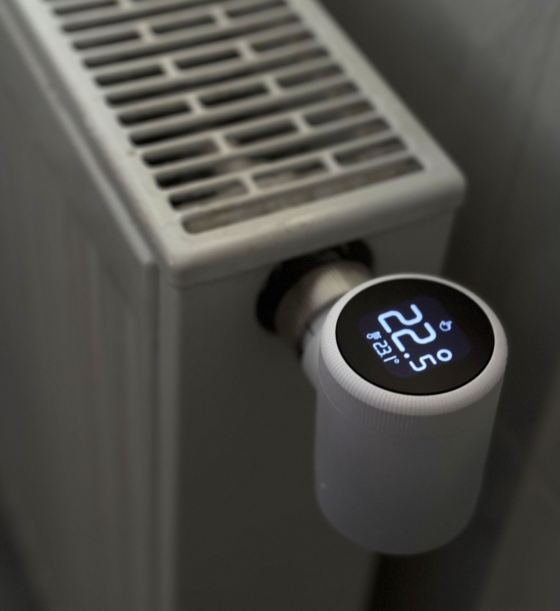 Thermostat intelligent blanc sur un radiateur, affichant une température de 22,5 °C.