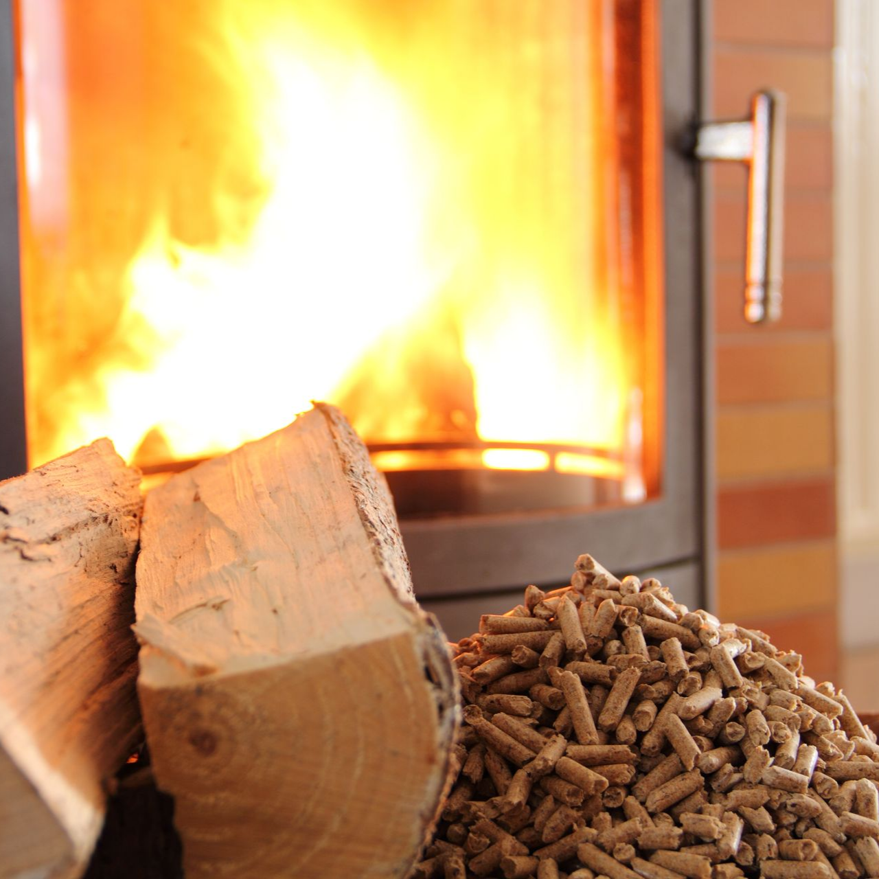 Du bois et des granulés de bois près d'une cheminée avec des flammes.