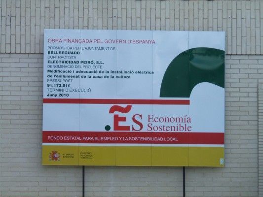 Un cartel en una pared de ladrillos que dice economía sostenible
