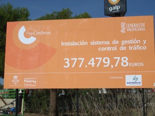 A large orange billboard that says instalacion sistema de gestion y control de trafico