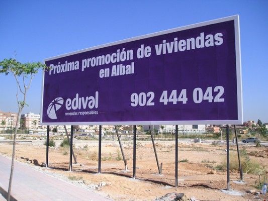 Un cartel violeta con el número 902 444 042