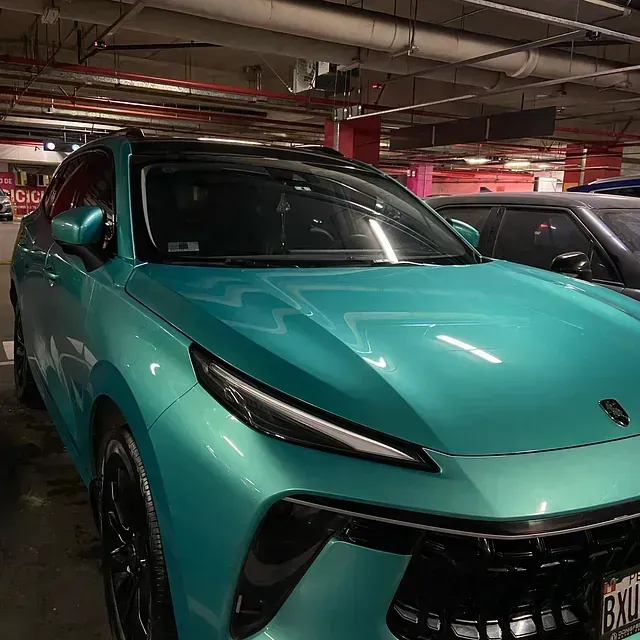 SUV Lamborghini Urus color turquesa brillante estacionado en un estacionamiento interior.