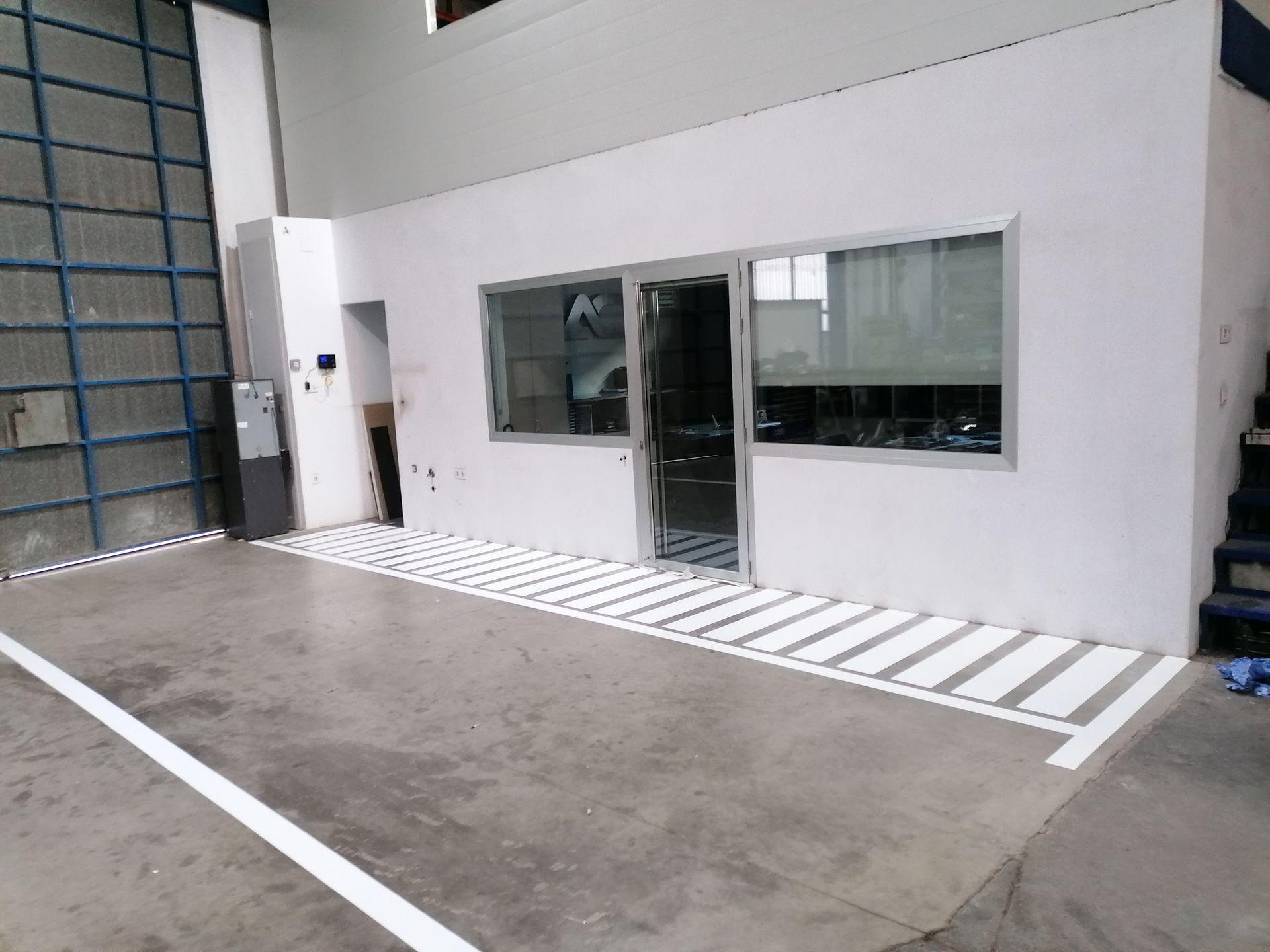 Un edificio con muchas ventanas y un lugar de estacionamiento para discapacitados frente a él.