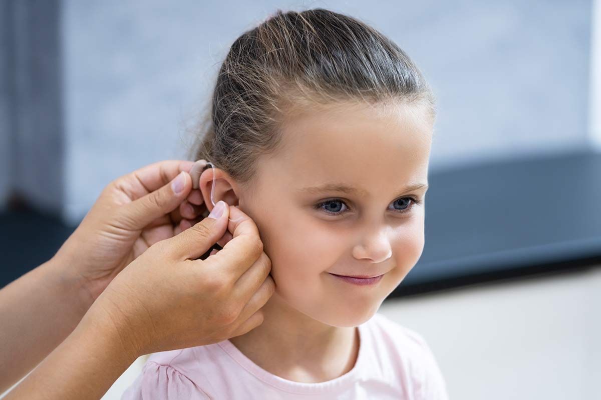 Petite fille à qui on installe un appareil auditif