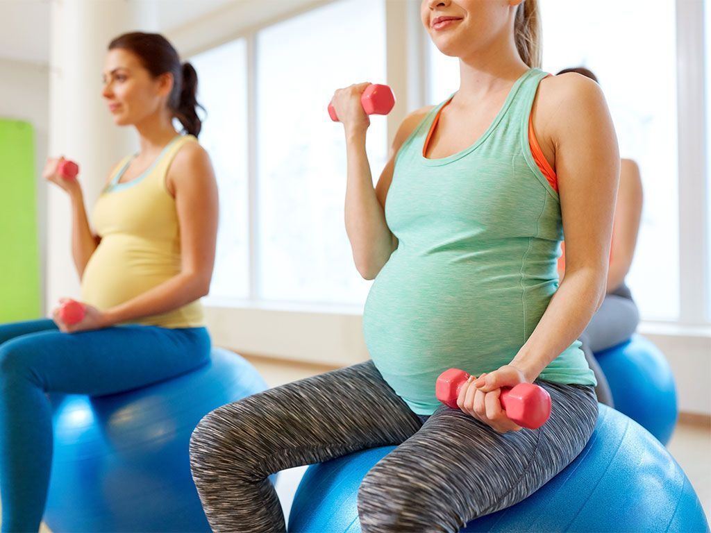Schwangere machen Sport auf Medizinbällen