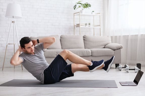 Fitness Mann treibt Sport Zuhause Onlinekurs