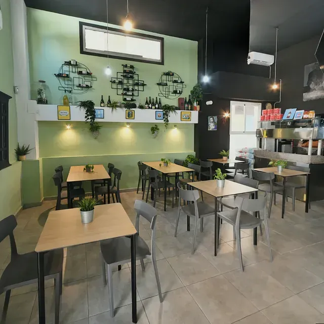 Un restaurante con mesas y sillas y plantas en las mesas.