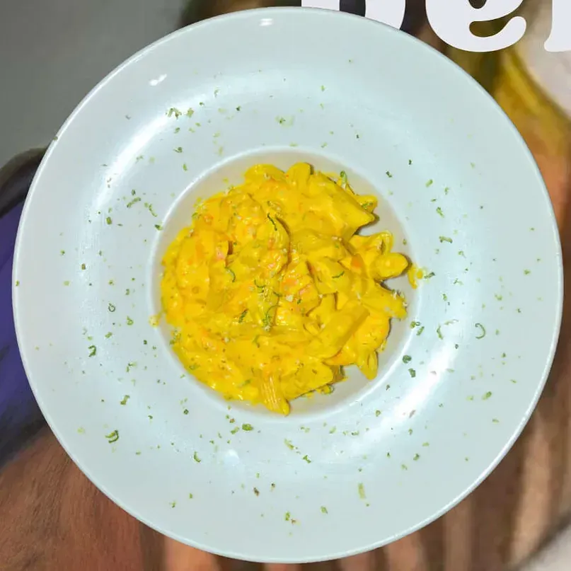 Un plato blanco con un tazón de salsa amarilla encima.