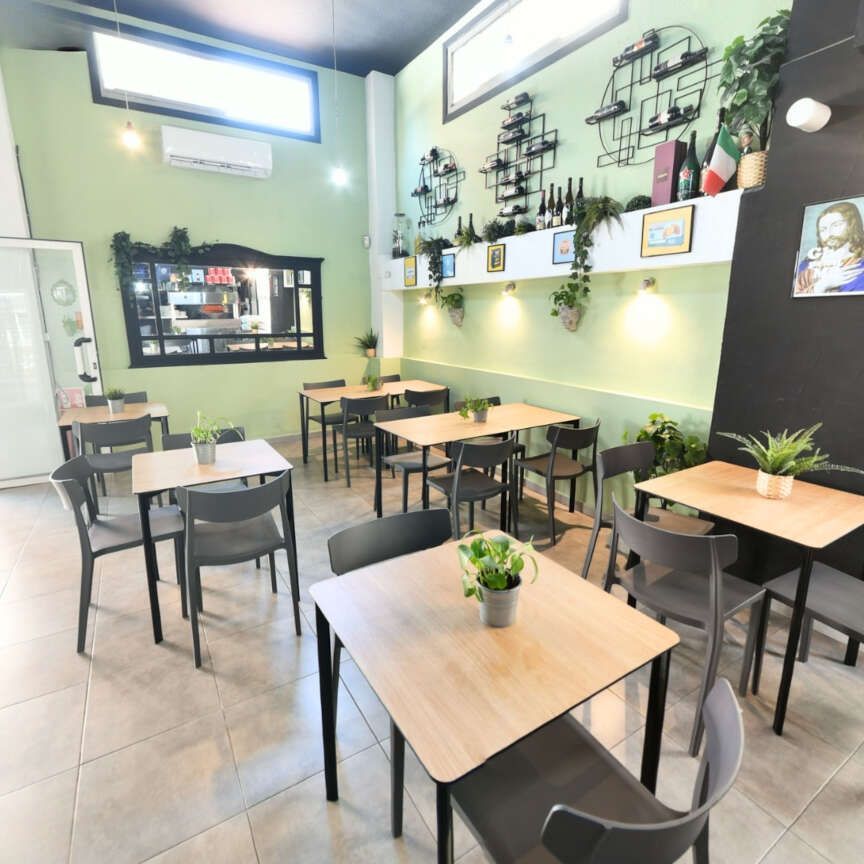 Un restaurante con mesas y sillas y una imagen de Jesús en la pared.