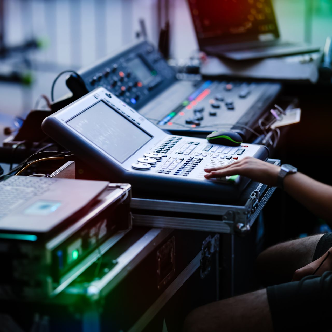 Personne utilisant un équipement de mixage audio, contrôlant une table d'harmonie avec un écran.