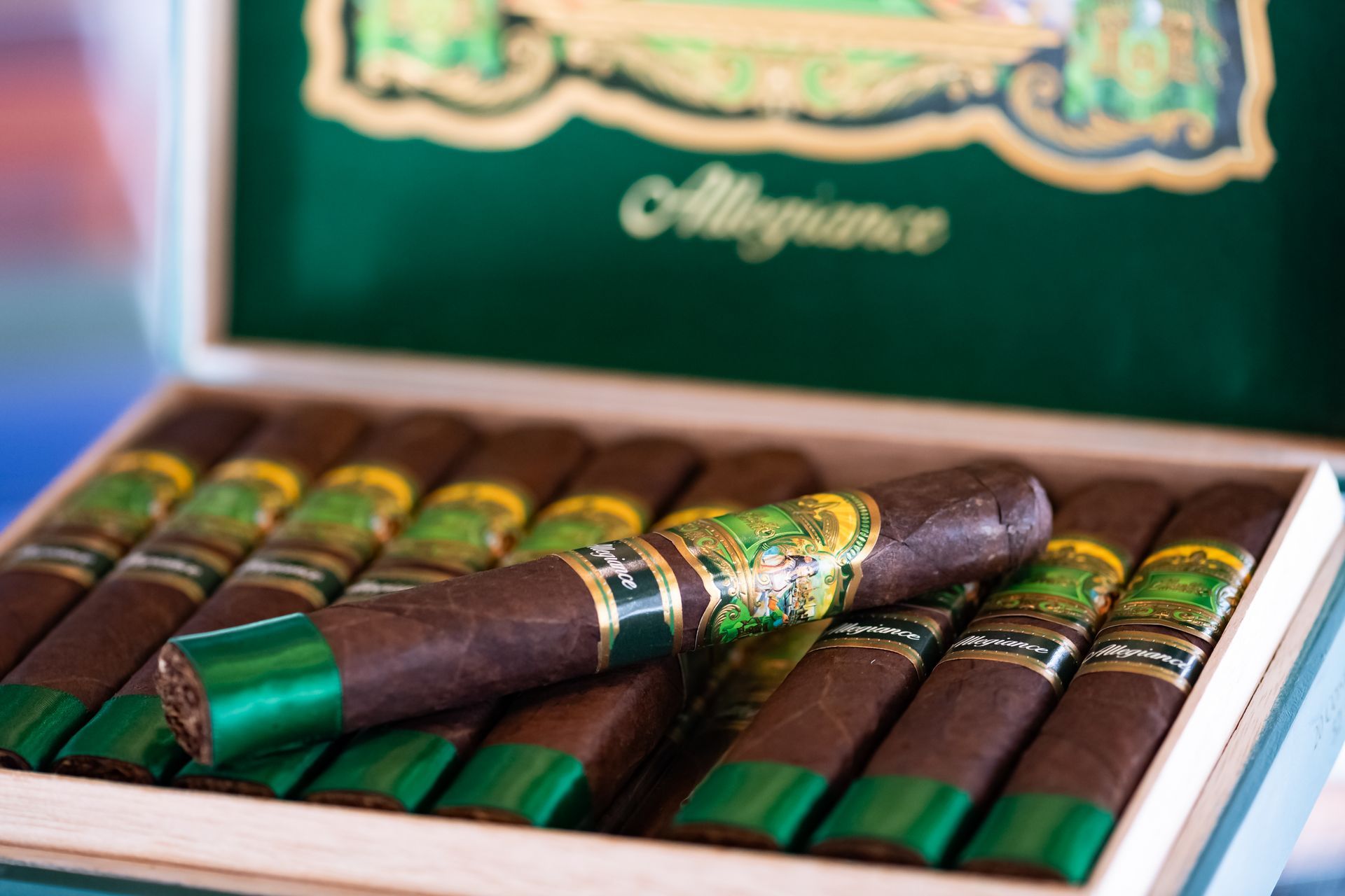 Une boîte de cigares avec des emballages verts est posée sur une table.