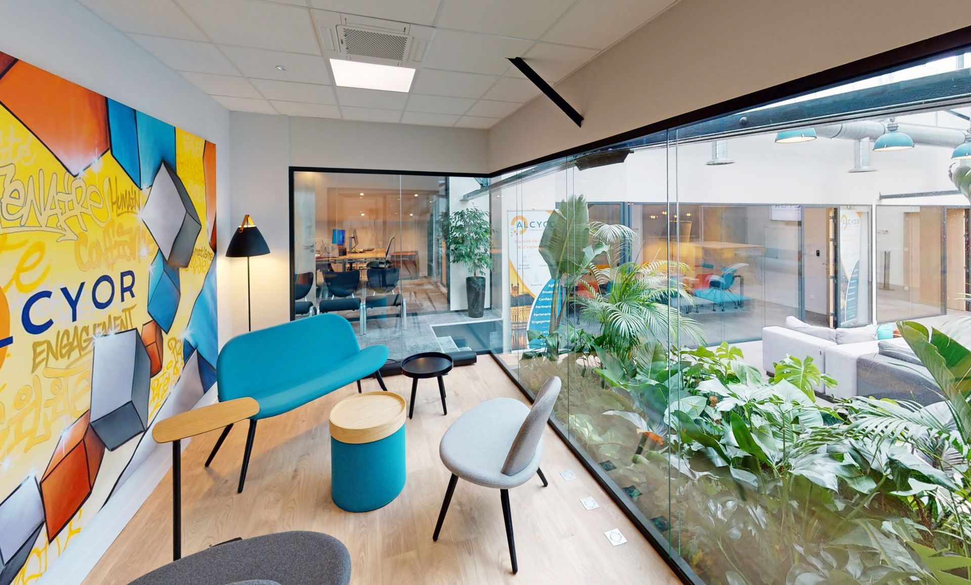 Salon d'attente avec meubles colorés donnant sur un patio intérieur