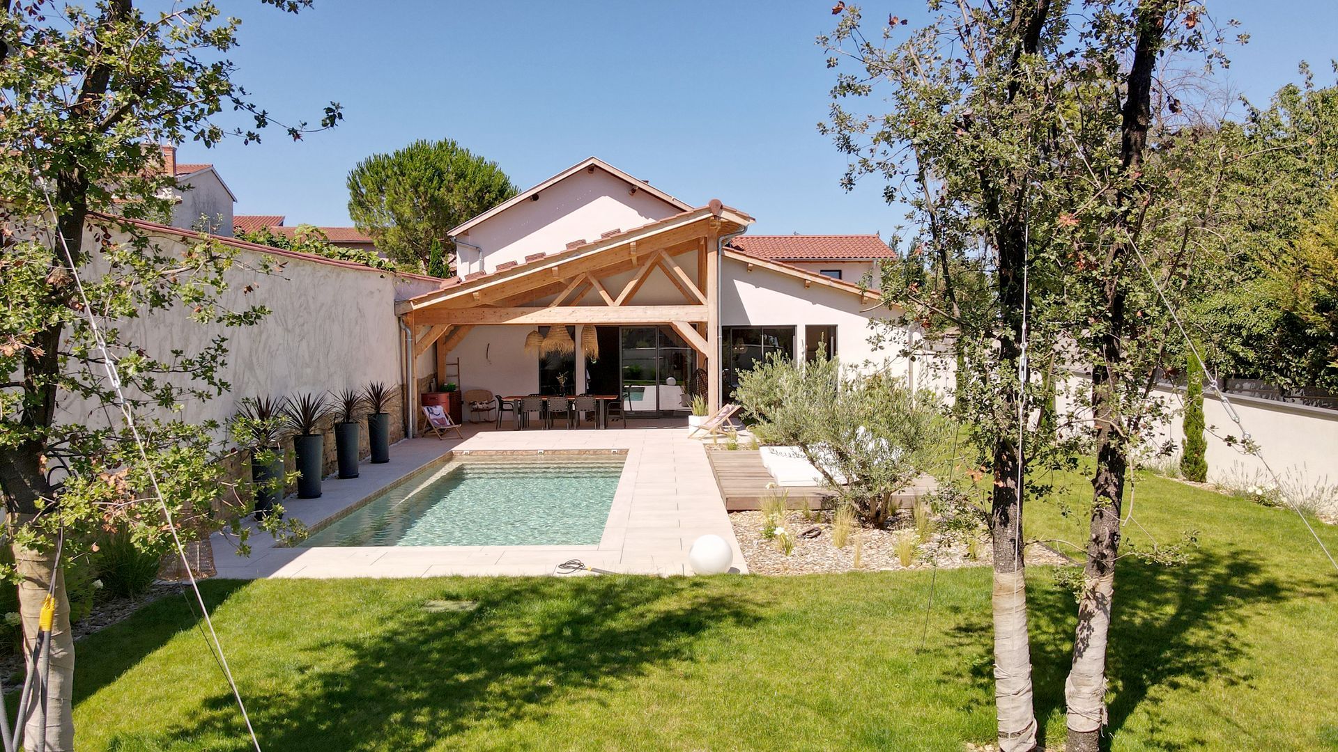 Maison rénovée avec un jardin à l'herbe bien verte et une piscine creusée