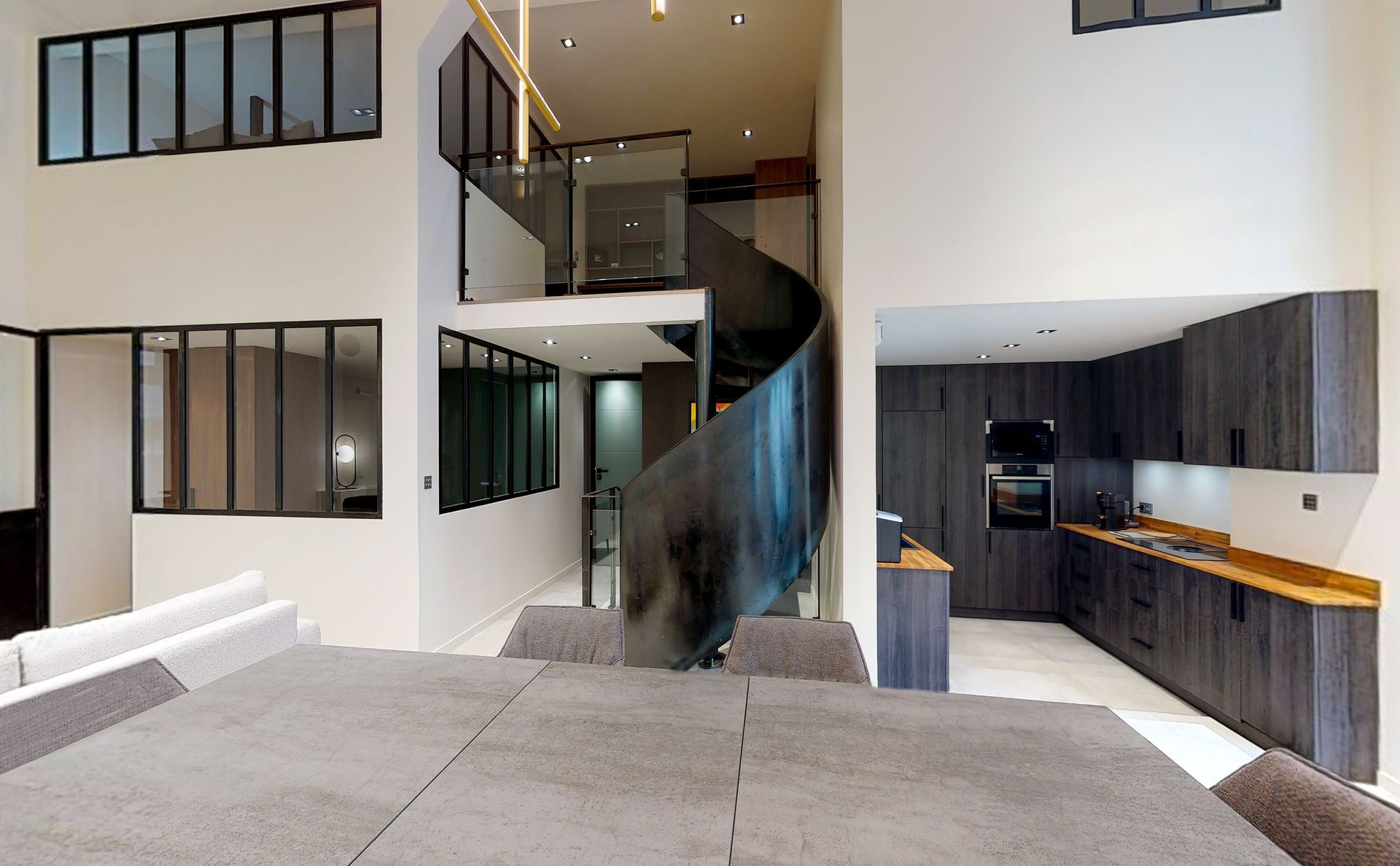 Duplex avec vue sur l'escalier intérieur en colimaçon donnant sur la pièce à vivre