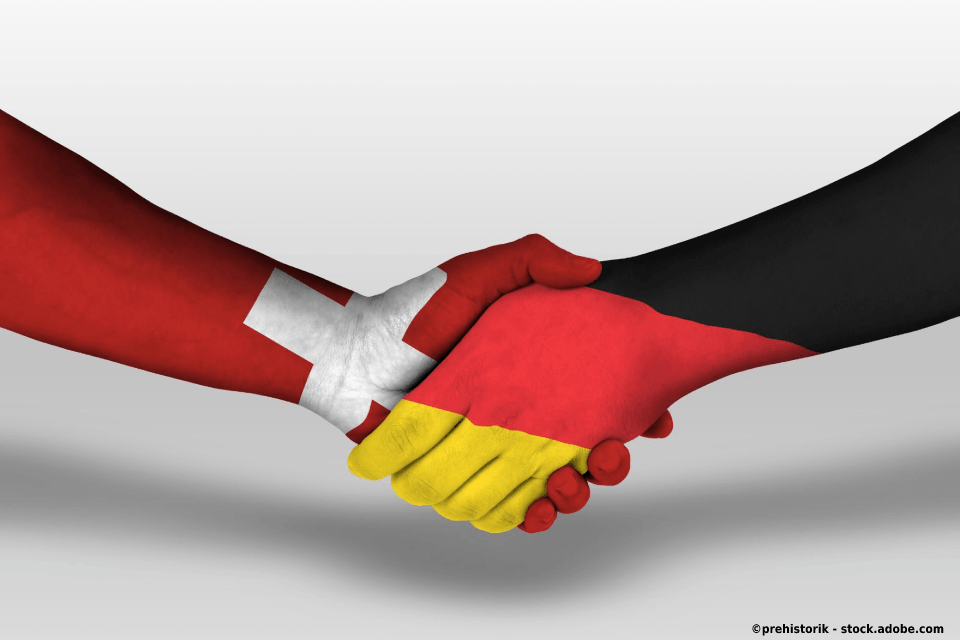 Handschlag Hände bemalt mit Schweiz und Deutschland Flagge