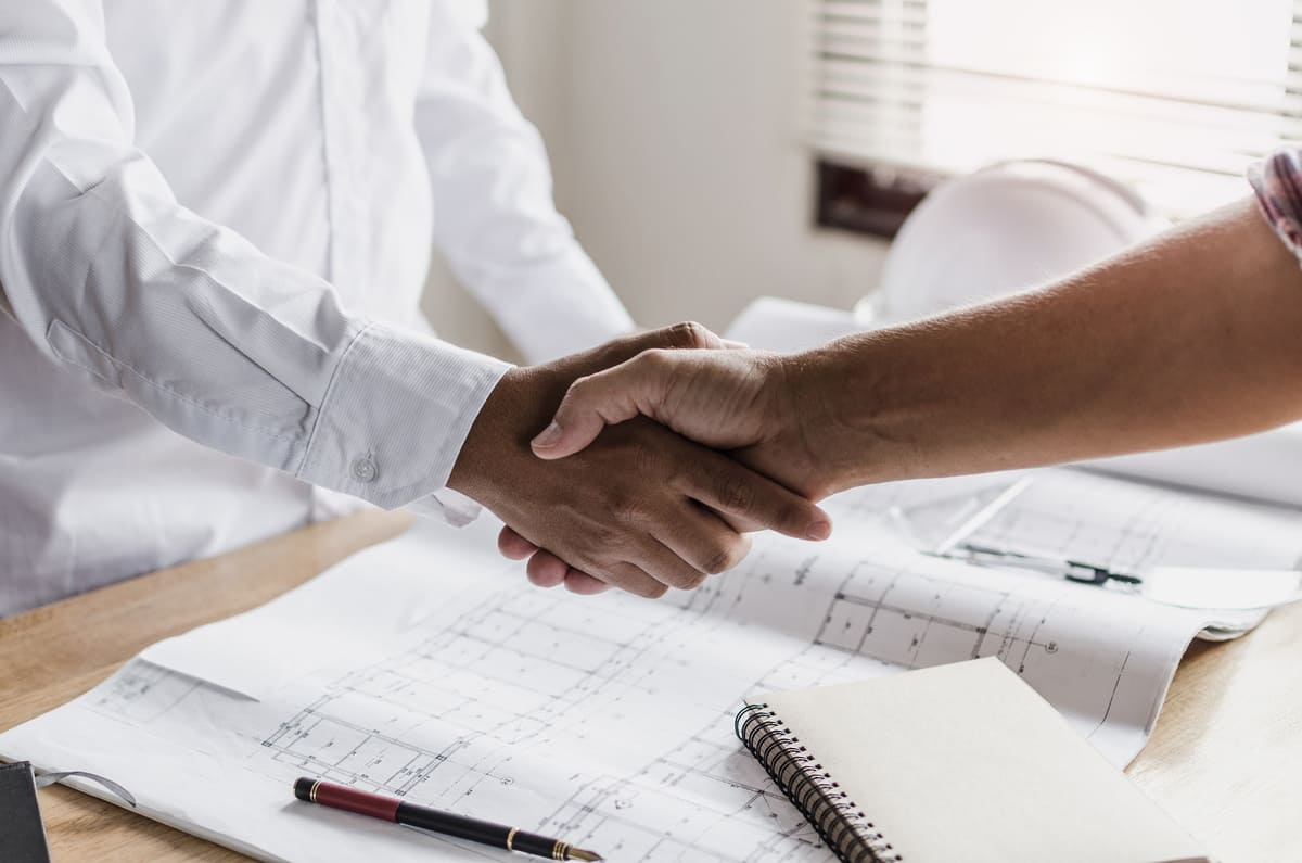 Poignée de main au dessus d'un plan