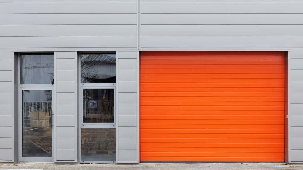 Bardage métallique gris porte roulante orange