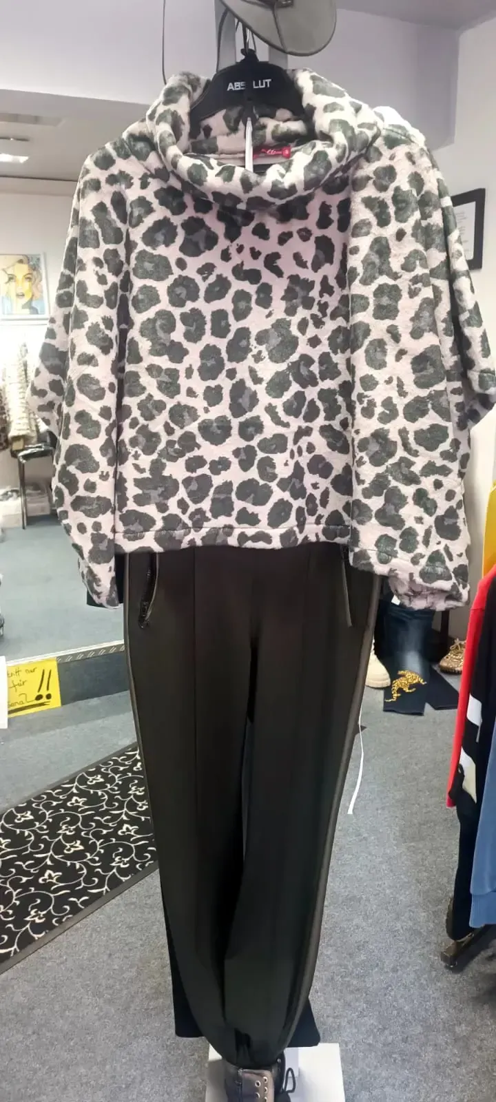 Leopardenmuster-Hoodie mit schwarzer Hose an einer Schaufensterpuppe
