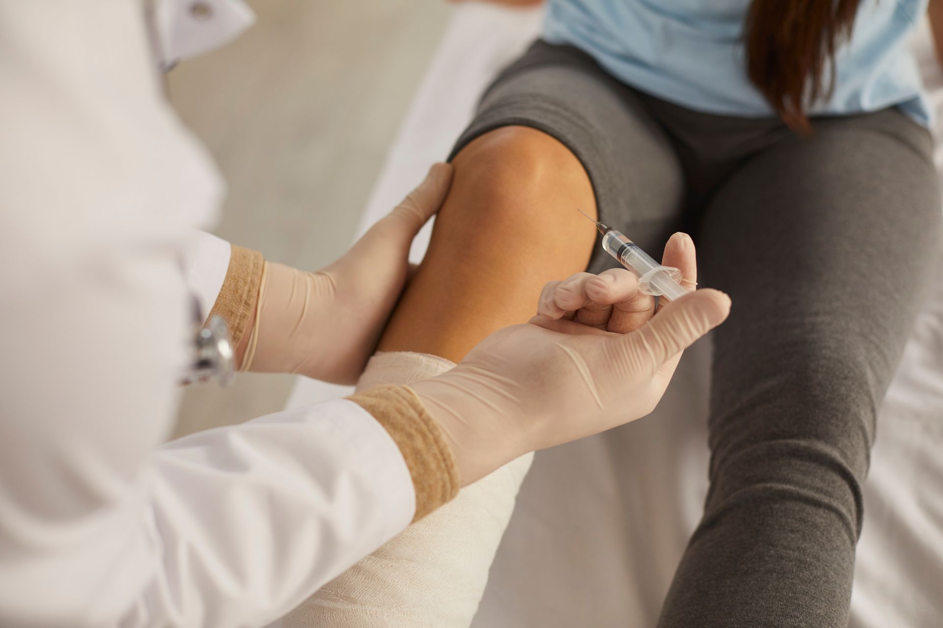 Gros plan d'un professionnel de santé administrant une injection à un patient dans un environnement clinique