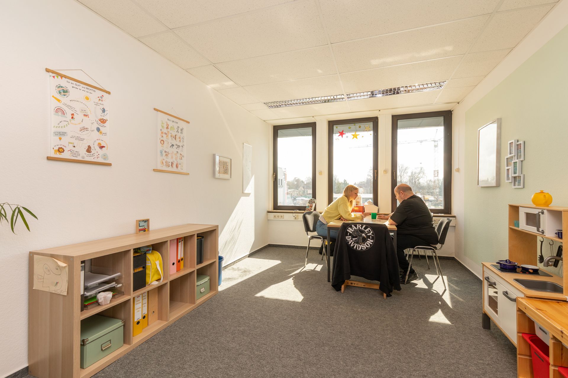 Logopädin arbeitet mit einem Kind an Sprachübungen, unter Verwendung von bunten Spielmaterialien, als Teil der Sprachtherapie in Hamburg Wandsbek.