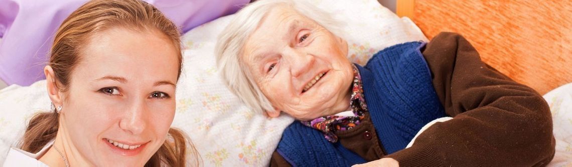 Una mujer mayor está acostada en una cama junto a una mujer más joven.