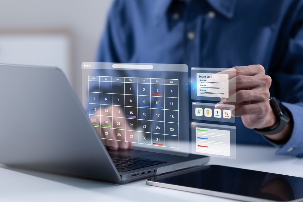 Persona usando una computadora portátil con una superposición de calendario digital transparente e interfaz de panel de control.