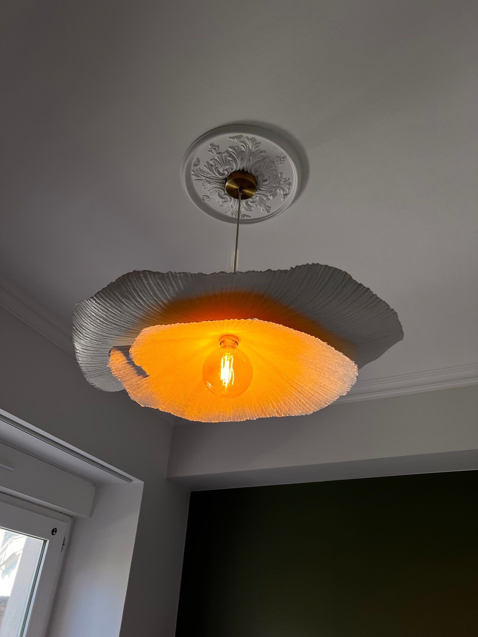 Plafonnier moderne à lumière orangée et abat-jour argenté texturé dans un coin de pièce