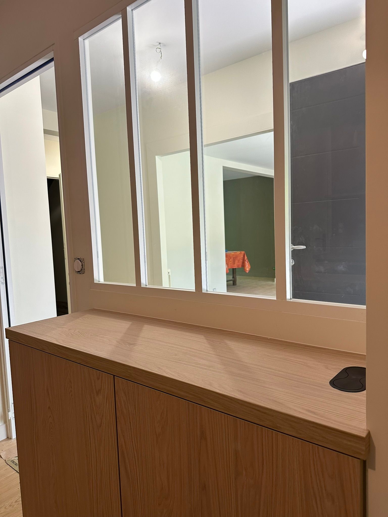 Comptoir en bois avec panneaux de miroir en arrière-plan, dans un couloir ou un hall d'entrée.