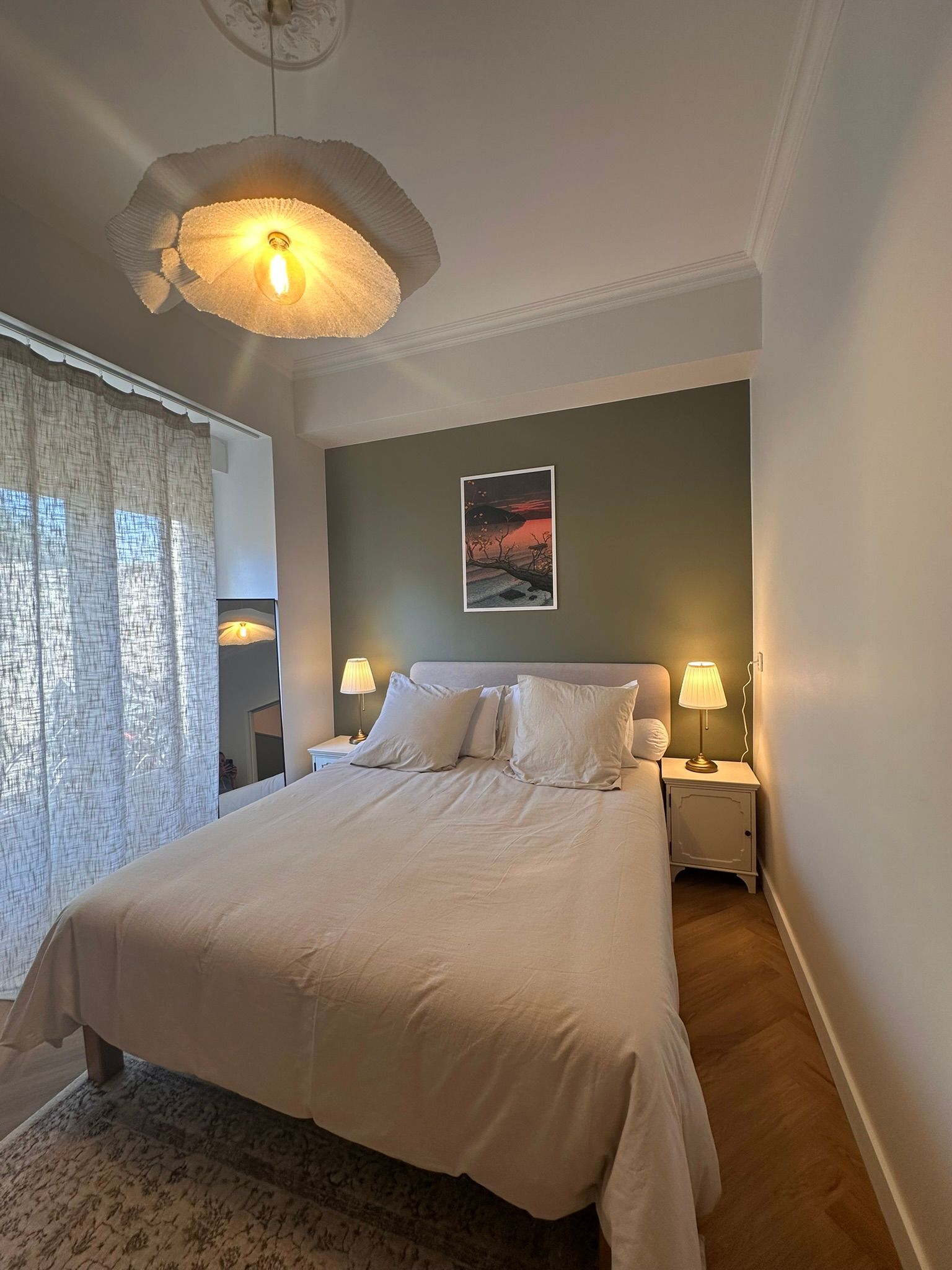 Chambre confortable avec un lit bien fait, des lampes de chevet et une douce lumière du jour filtrant à travers des rideaux