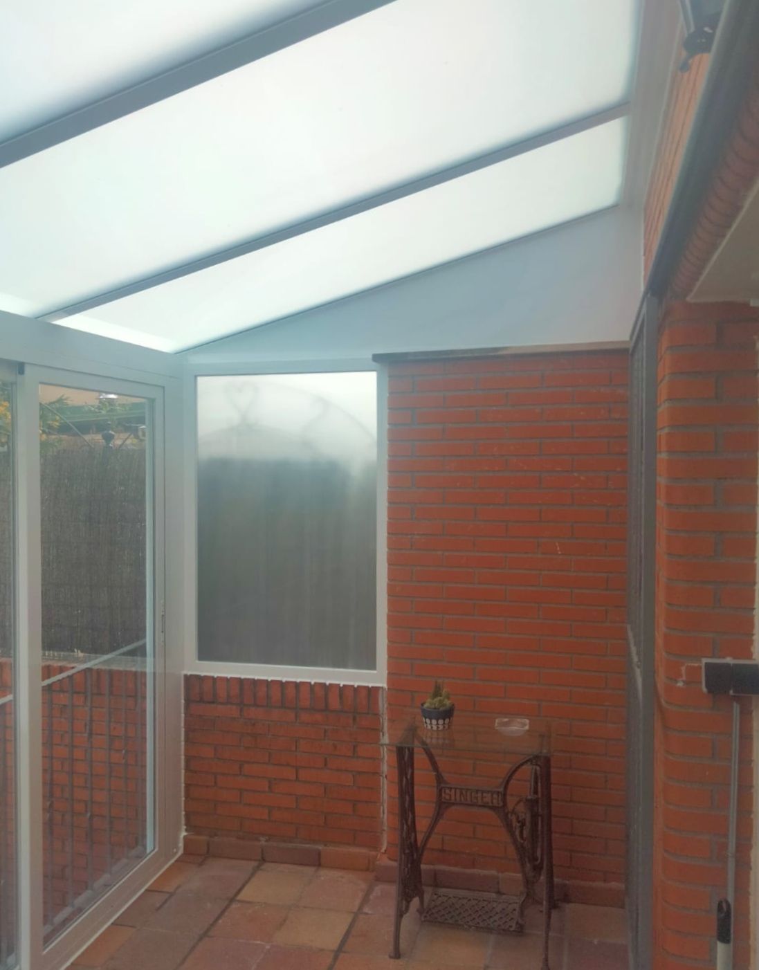 Una habitación con una mesa y sillas y una pared de ladrillos.