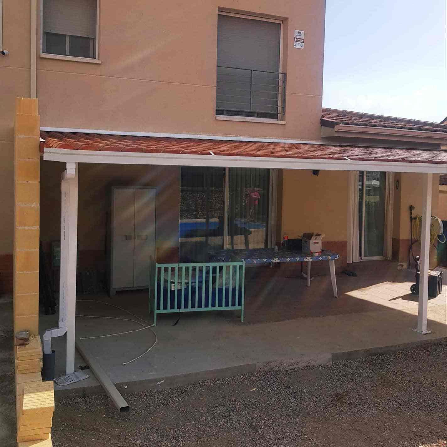 Una casa con un porche cubierto y un cartel que dice 'a' en él