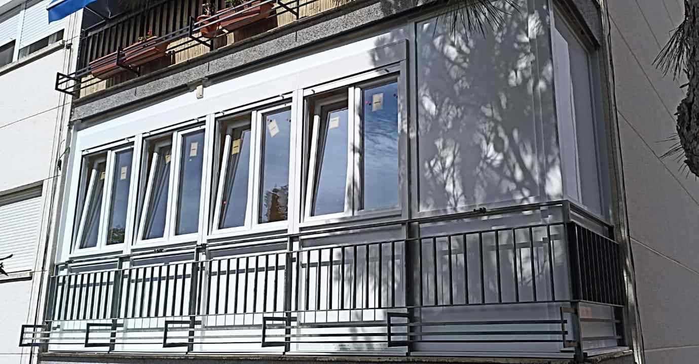 Un balcón con muchas ventanas en el costado de un edificio.