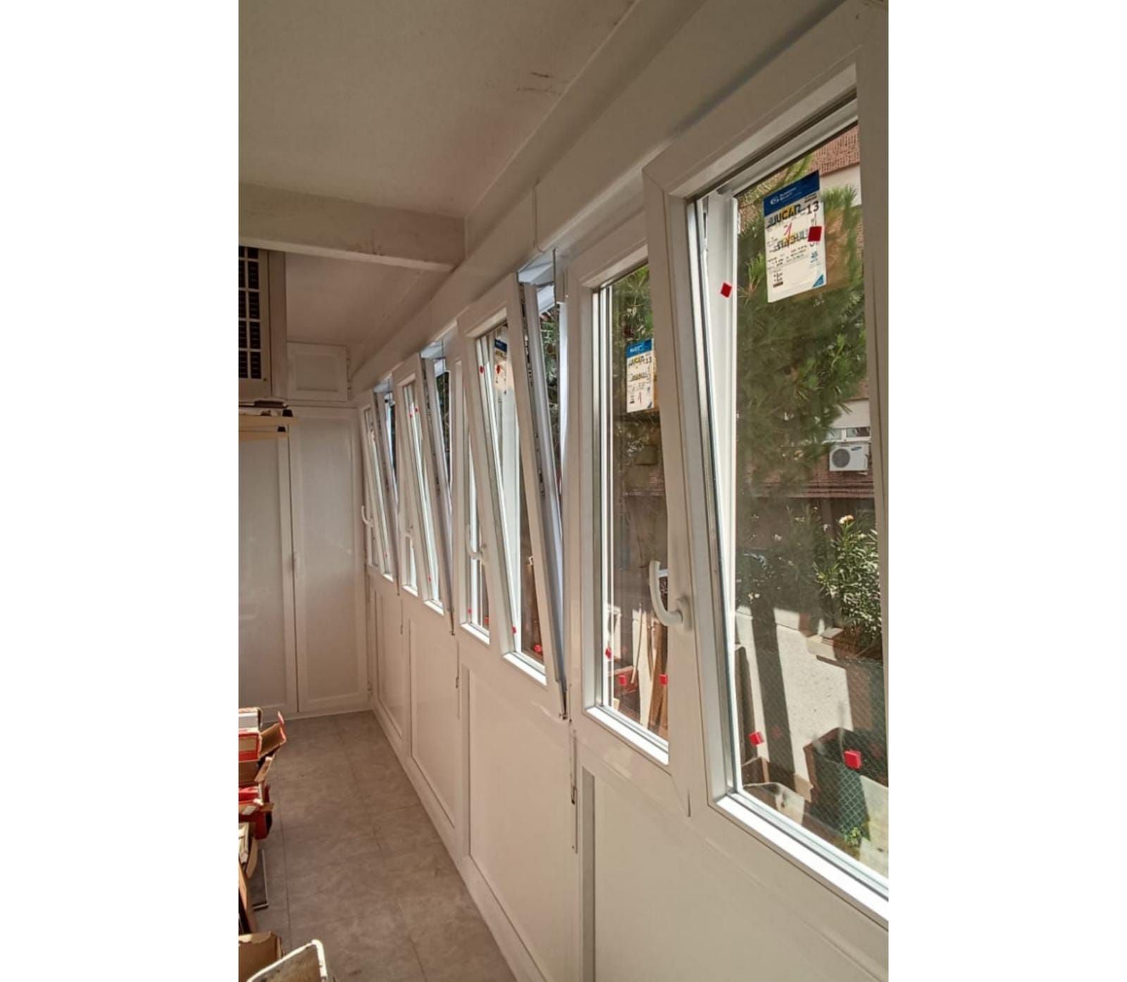 Un pasillo largo con muchas ventanas y puertas.