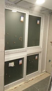 Se están instalando dos ventanas en un baño.