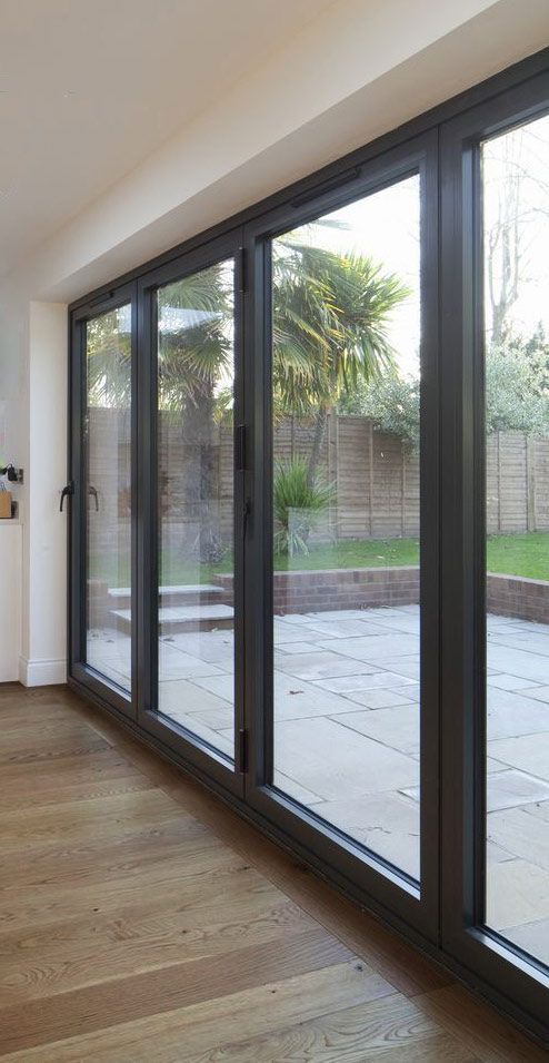 Una habitación con muchas ventanas y suelo de madera.