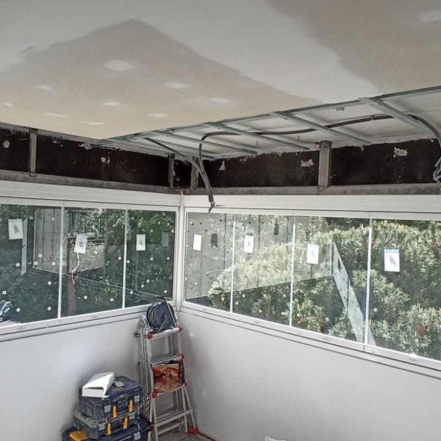 Una habitación con muchas ventanas y una escalera.