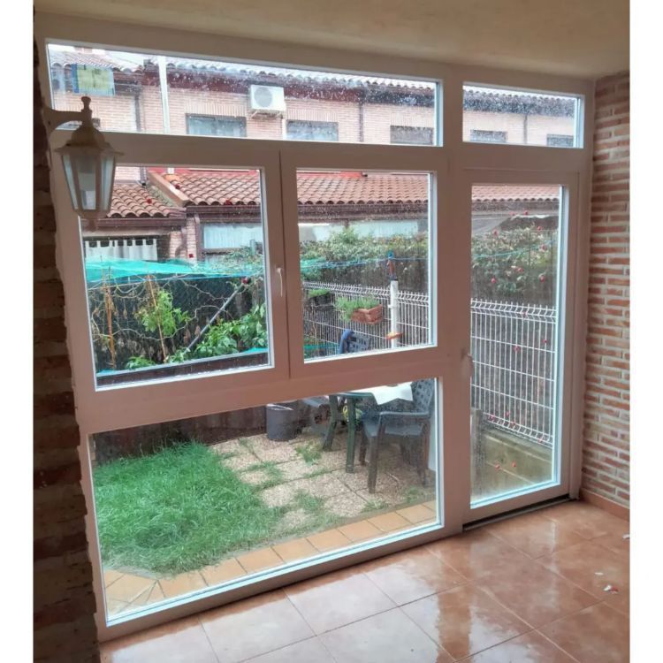 Una habitación con muchas ventanas que dan a un jardín.