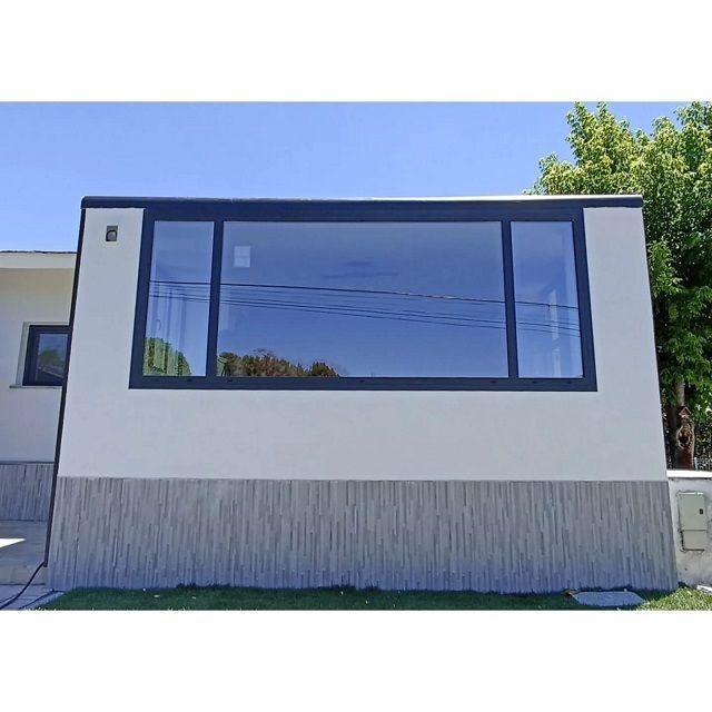 Una casa con una gran ventana en el costado.