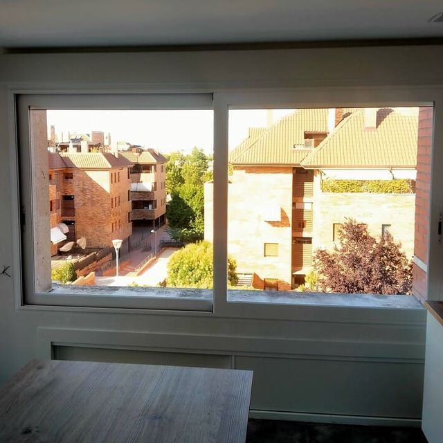 Una gran ventana con vista a un edificio de ladrillo.