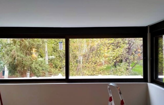 Una habitación con una ventana grande y una escalera en ella.