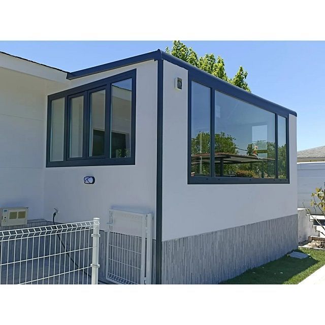 Una casa blanca con muchas ventanas y una valla