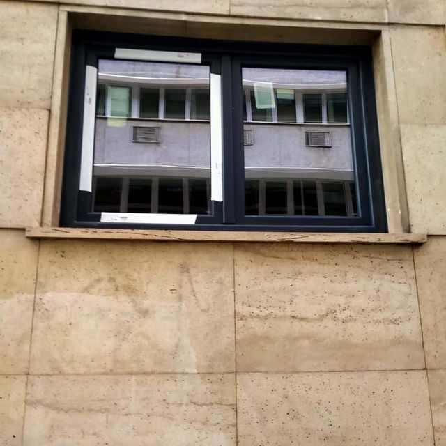 Una ventana en el lateral de un edificio con un marco negro.