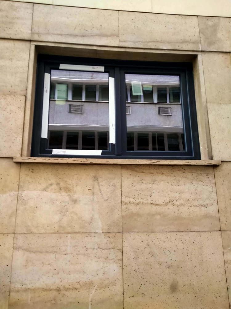 Una ventana en el lateral de un edificio con un marco negro.