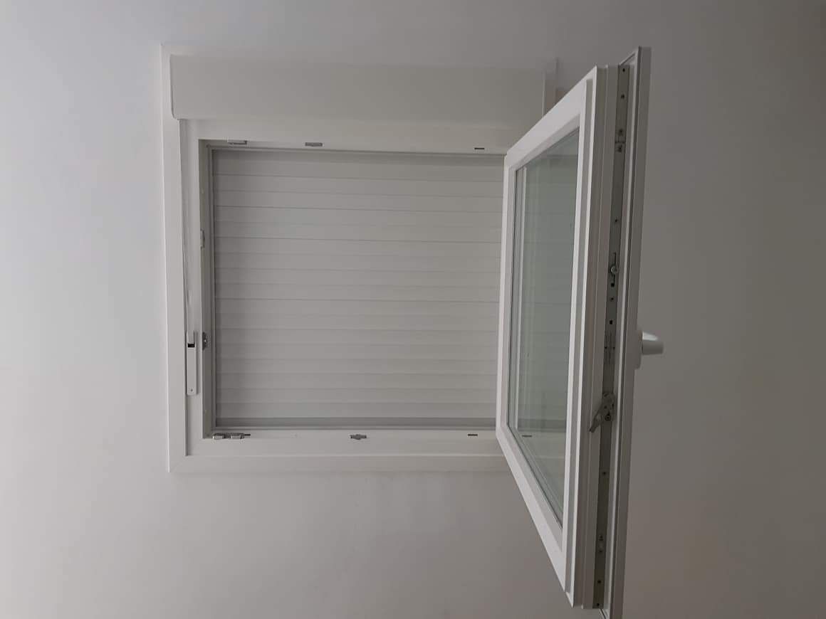 Una ventana blanca está abierta en una pared blanca.