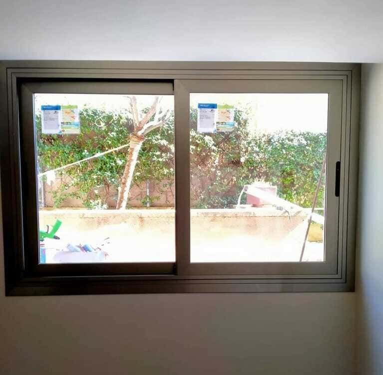 Una ventana corrediza de vidrio en una habitación con vista a un jardín.
