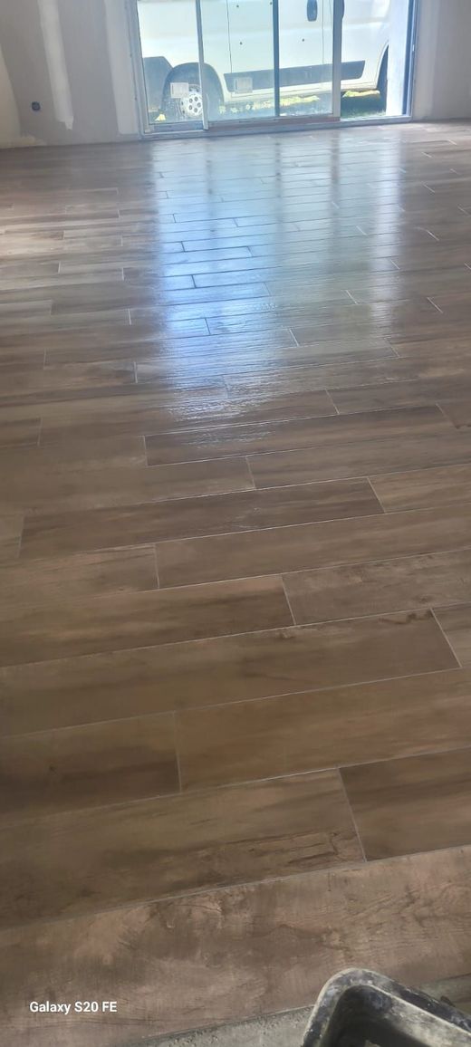 Plancher en bois avec reflets d'une fenêtre, montrant une pièce.