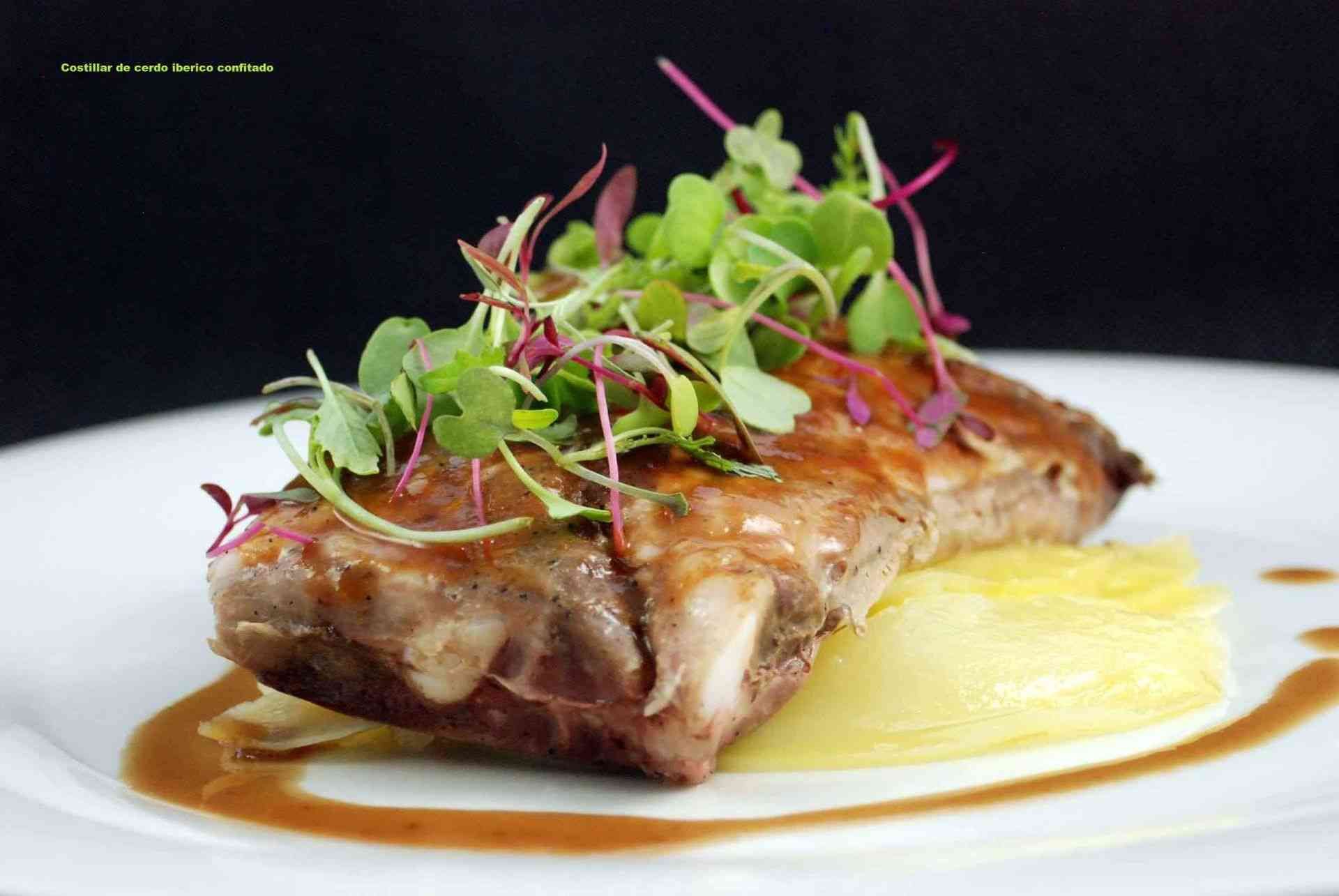 Cerdo asado con verduras, servido sobre puré de papas, adornado con salsa en un plato blanco.